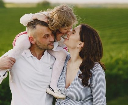 A delightful family moment captured in a lush scenic field, portraying love and happiness.