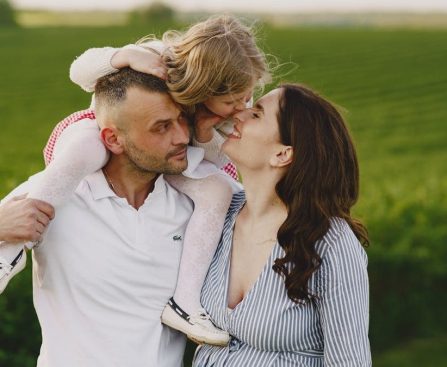 A delightful family moment captured in a lush scenic field, portraying love and happiness.